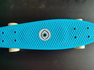 Monopatín azul con diseño de ojo