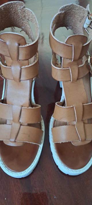 Sandalias marrón con suela blanca.