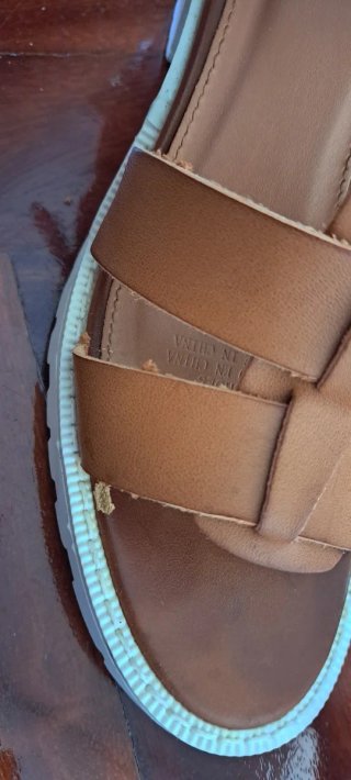 Sandalias marrón con suela blanca.