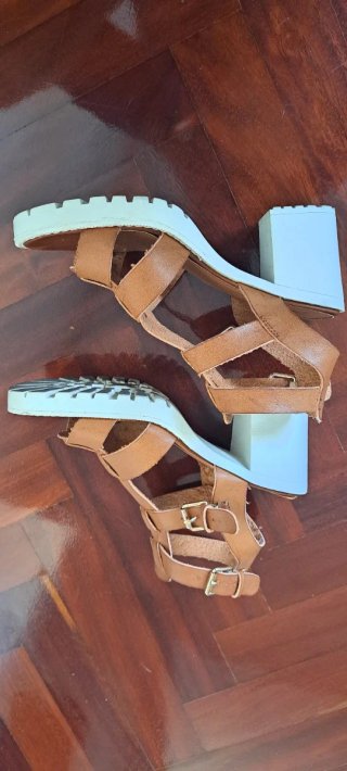 Sandalias marrón con suela blanca.