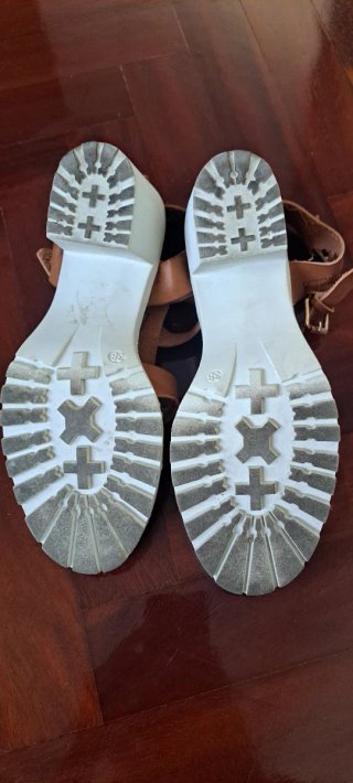 Sandalias marrón con suela blanca.