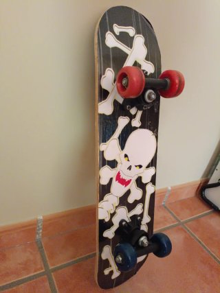 Monopatín con diseño de calavera y huesos