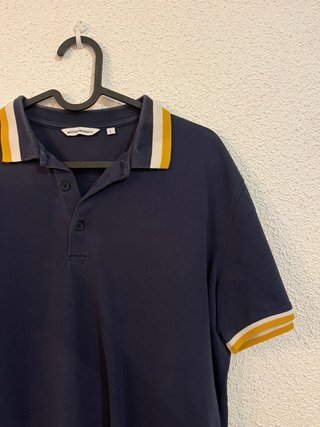 Polo azul marino con detalles amarillos