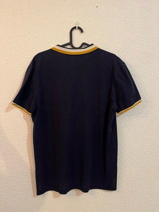 Polo azul marino con detalles amarillos