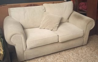 Sofá de tela beige con cojines
