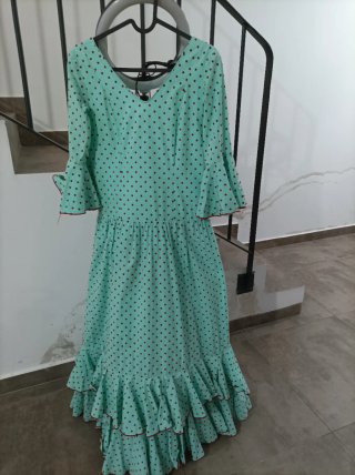 Traje de flamenca verde con lunares rojos .