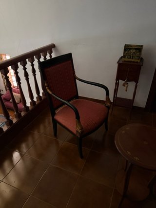 Sillón tapizado en tela roja y detalles dorados