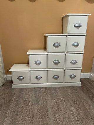 Mueble de madera blanco con cajones.