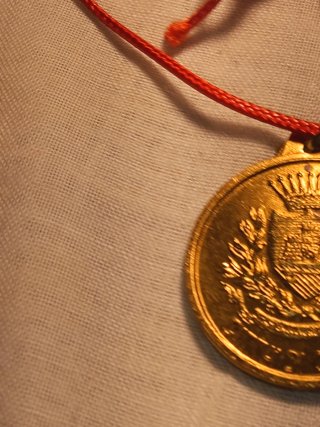 Medaglia dorata con cordino rosso