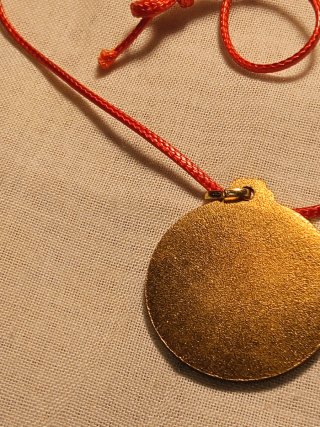 Medaglia dorata con cordino rosso