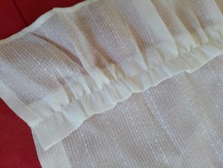 Cortina de tela blanca con volantes
