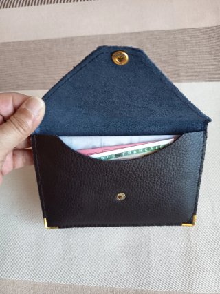Cartera de piel marrón con detalles dorados