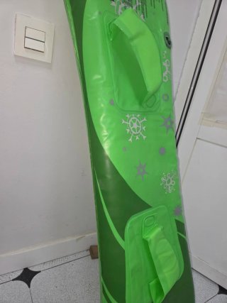 Colchoneta hinchable de tabla snowboard verde.