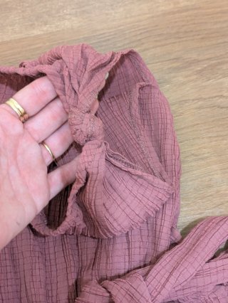 Mono rosa de una manga con cinturón