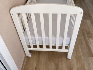 Cuna blanca con ruedas y colchones casi