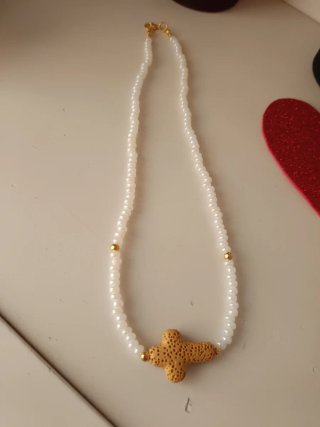 Collar blanco con cruz dorada