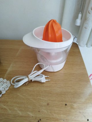 Exprimidor eléctrico naranja y blanco