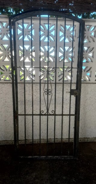 Puerta de forja con un diseño elegante y curvo en