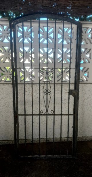 Puerta de forja con un diseño elegante y curvo en