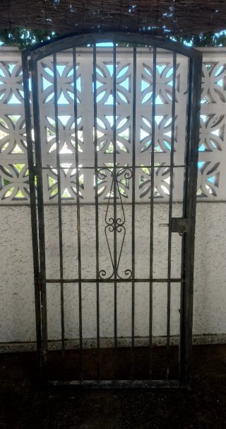 Puerta de forja con un diseño elegante y curvo en