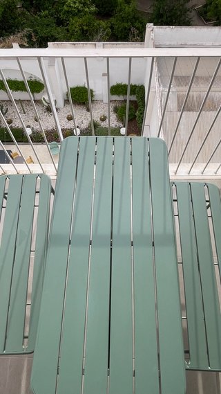 Mesa de exterior metálica con sus 2 bancos