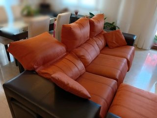 Sofá Chaiselongue color naranja y chocolate.