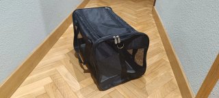 Transportín negro para gato o perro pequeño.
