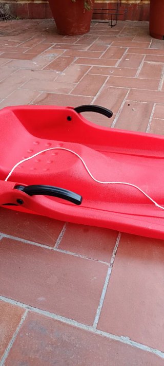 Trineo rojo de plástico con cuerda