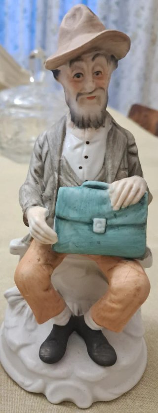 Statuine coppia anziani con gatto e valigetta