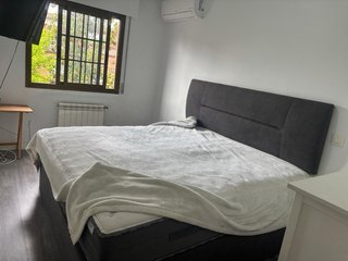 Cama tapizada gris con cabecero y colchon