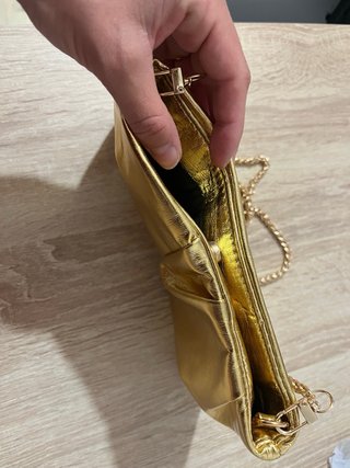 Bolso de mano dorado con cadena