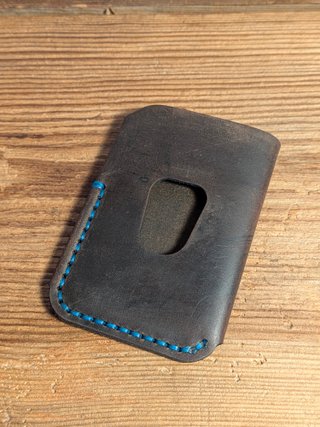 Cartera artesanal de piel marrón con costura azul