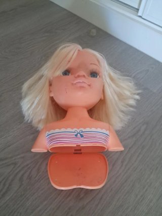 Cabeza de muñeca con peinado y maquillaje