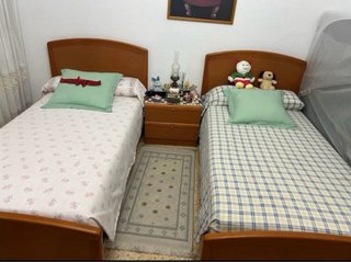 Due letti in legno con materassi nuovi e cassettiera.
