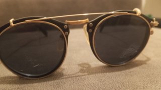 Gafas de sol ovaladas negras y doradas