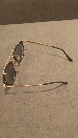 Gafas de sol ovaladas negras y doradas