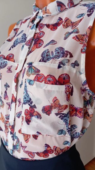 Blusa sin mangas con estampado de mariposas.