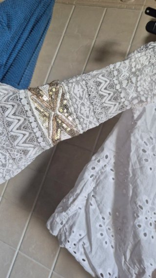 Top bianco con ricami oro e frange