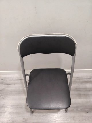 Silla plegable negra y plateada.