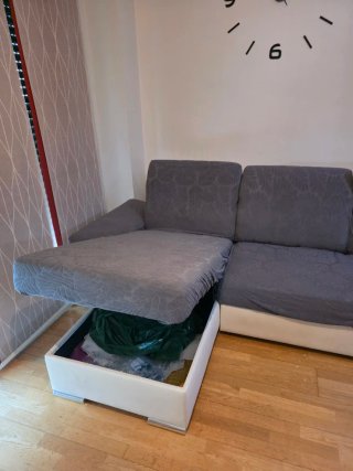 Sofá cama blanco con fundas de tela grises