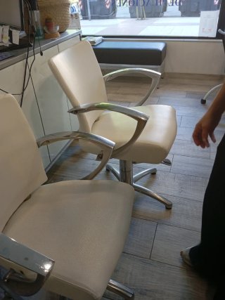 Sillones de peluquería plateados y blancos