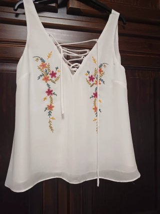 Blusa blanca con bordado floral.