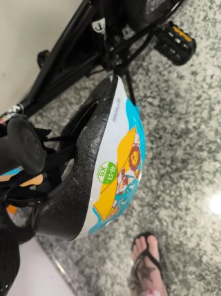 Bicicleta infantil con casco, cesta y mochila.