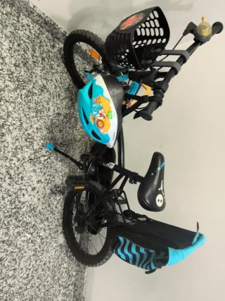 Bicicleta infantil con casco, cesta y mochila.