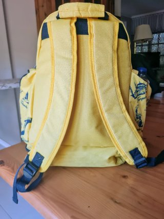 Mochila amarilla con estampados de viajes
