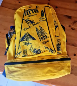 Mochila amarilla con estampados de viajes