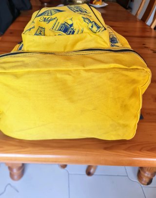 Mochila amarilla con estampados de viajes