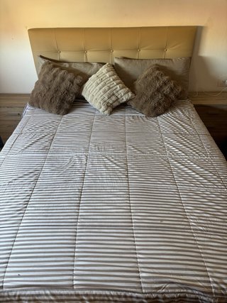 Cama tapizada beige y marrón