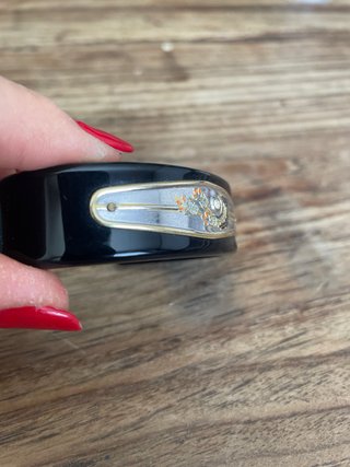 Bracciale rigido nero con dettagli oro