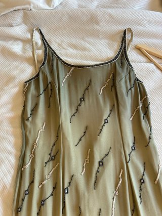 Vestido largo beige y verde con pedrería.